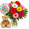 Happy birthday package with bright mixed gerberas and a teddy and balloon