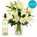 Beautiful lilies with a bottle of white wine