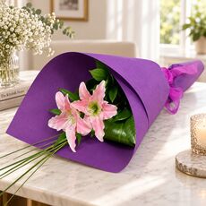 2 pretty wrapped lily stems presented as a bunch with paper and ribbon