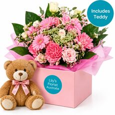 Pink flowers for a baby girl in a box with a teddy bear