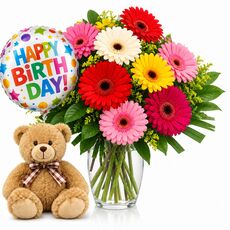 Happy birthday package with bright mixed gerberas and a teddy and balloon