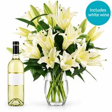 Beautiful lilies with a bottle of white wine
