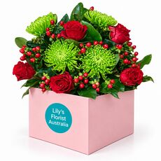 A lovely mix of red and green blooms designed to brighten a room