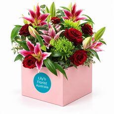 Red ruby blooms set in a box with a range of stunning fresh flowers