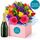 Bright mix of fresh blooms set in a box with a bottle of sparkling wine