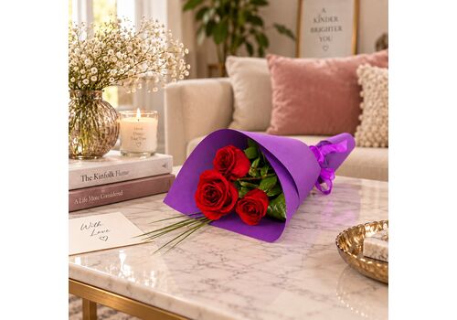 3 red roses wrapped in pretty paper with a bow