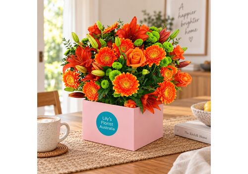 Mixed orange flowers set in to a lovely box