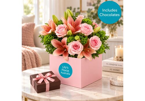 Blush pink mixed blooms in a box with a box of chocolates